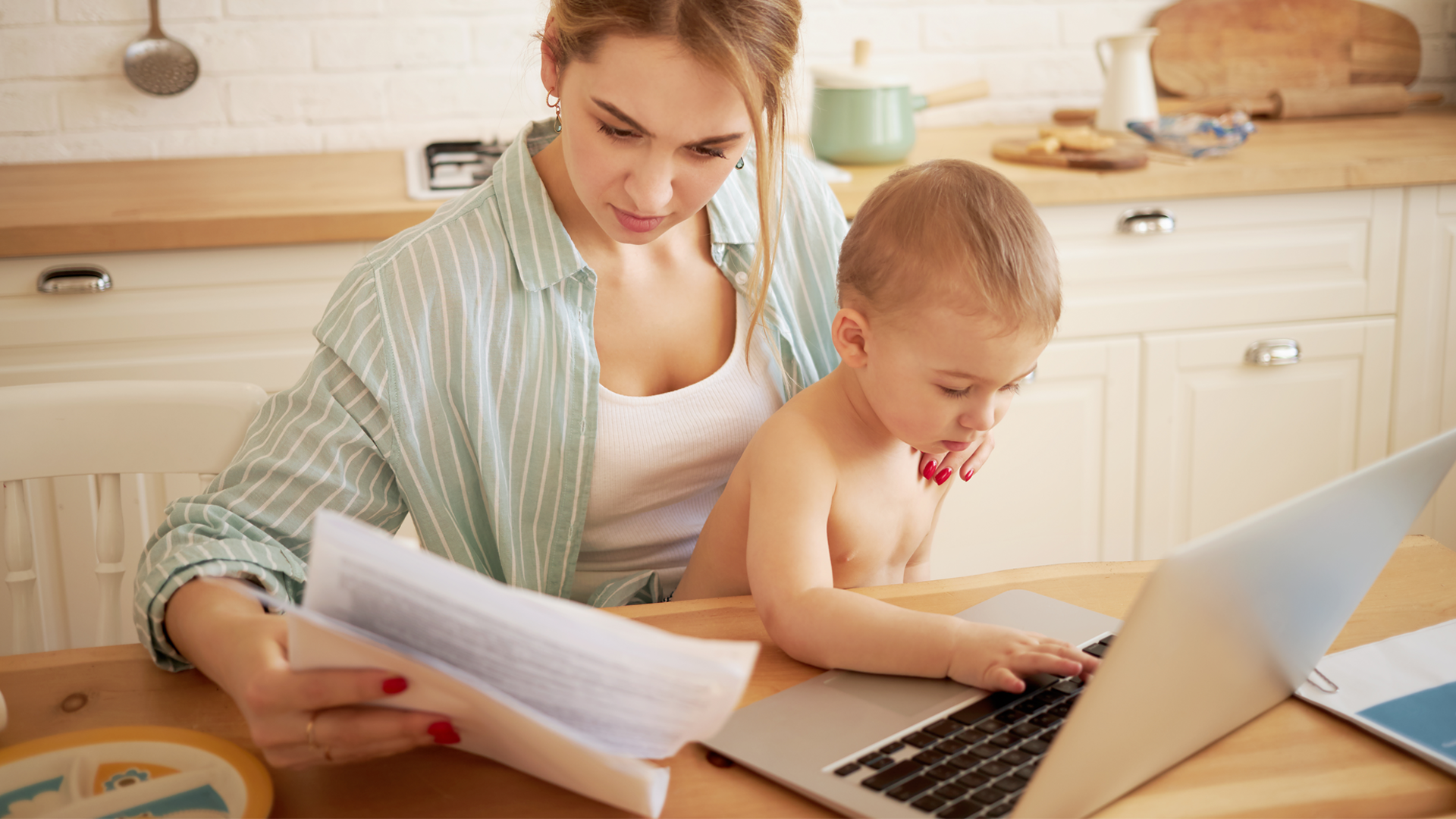 mom paying bills with baby on lap